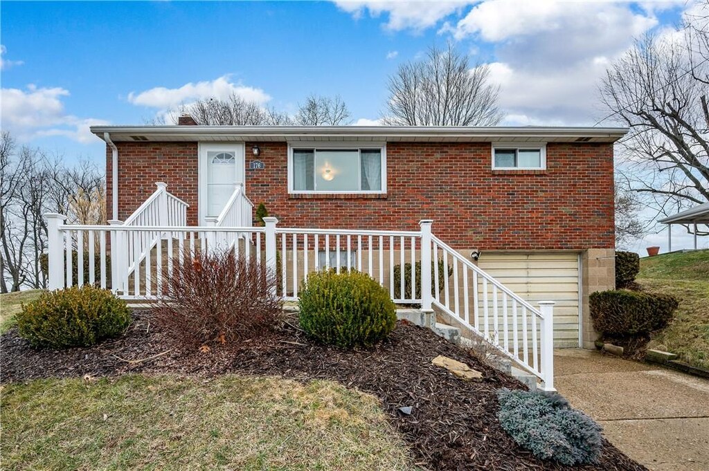 ranch-style home with an attached garage, concrete driveway, and brick siding