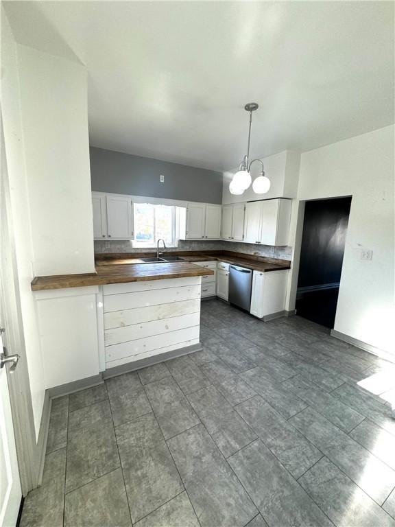 kitchen featuring a chandelier, a peninsula, white cabinetry, wooden counters, and stainless steel dishwasher