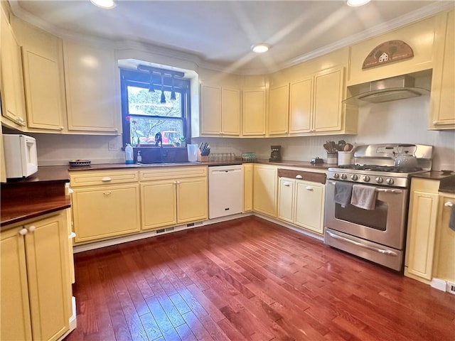 kitchen featuring gas range, wall chimney exhaust hood, cream cabinets, white dishwasher, and a sink