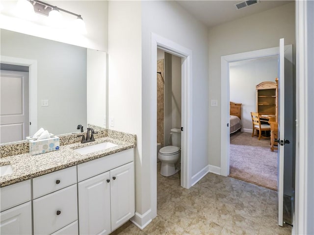 bathroom featuring toilet, a sink, double vanity, baseboards, and visible vents