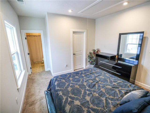 carpeted bedroom featuring attic access, baseboards, and multiple windows