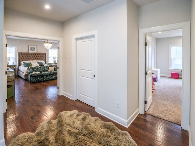 corridor with recessed lighting, hardwood / wood-style floors, a wealth of natural light, and baseboards