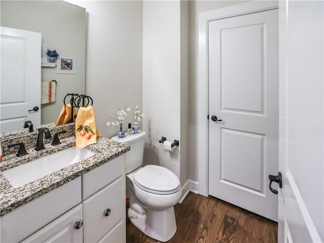 bathroom featuring toilet, vanity, and wood finished floors