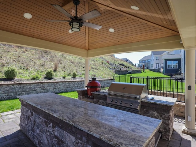 view of patio featuring grilling area, a ceiling fan, an outdoor kitchen, and fence