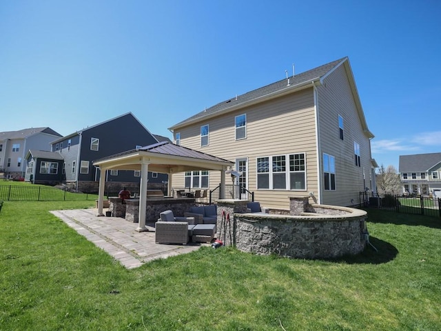 rear view of house with a fenced backyard, a gazebo, a patio area, a lawn, and area for grilling