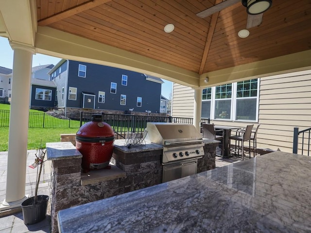 view of patio / terrace featuring outdoor dining space, a ceiling fan, a fenced backyard, exterior kitchen, and area for grilling