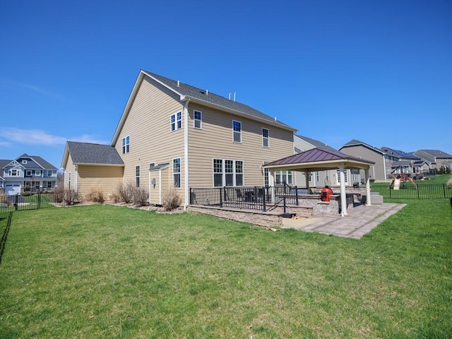 rear view of property featuring a fenced backyard, a gazebo, a yard, and a patio