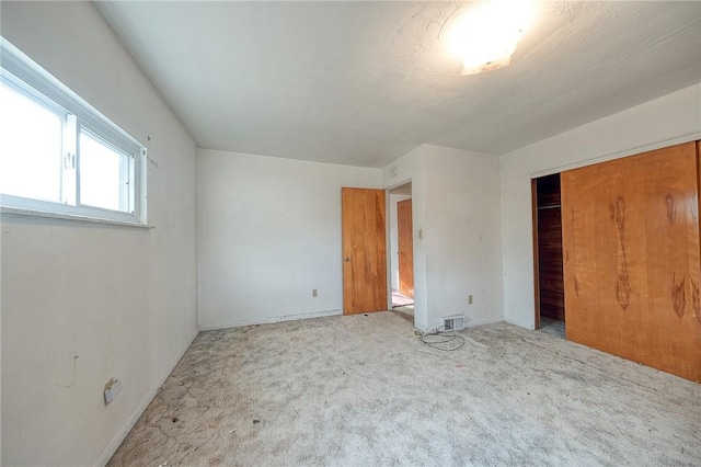 unfurnished bedroom featuring a closet, carpet flooring, and visible vents