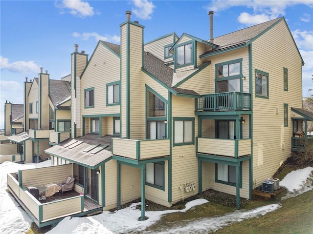 snow covered property with central air condition unit