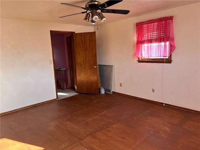 empty room featuring a ceiling fan and baseboards