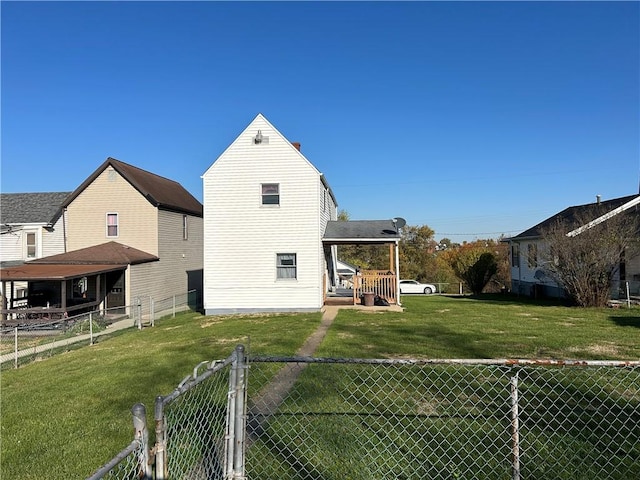 back of house with a fenced backyard and a yard