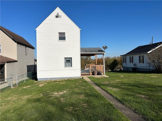 back of property featuring a lawn and fence