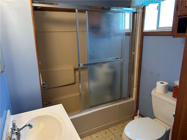 bathroom with combined bath / shower with glass door, a sink, and toilet