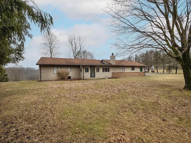 back of property with a yard and a chimney