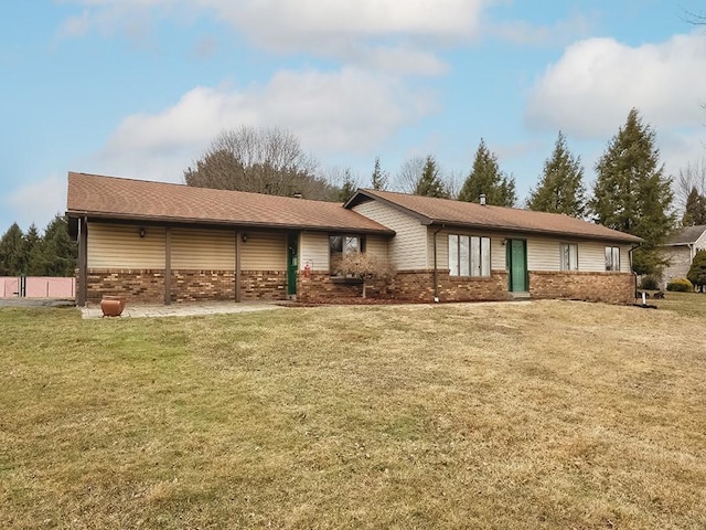 rear view of house featuring a yard and brick siding