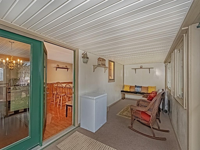 sunroom / solarium featuring a chandelier