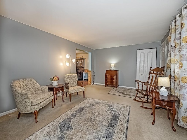 sitting room featuring light carpet and baseboards