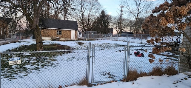 yard covered in snow with a gate and fence