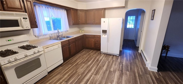 kitchen featuring arched walkways, white appliances, dark wood-style flooring, a sink, and light countertops