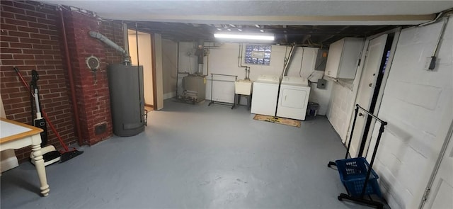 unfinished basement with water heater, a sink, and independent washer and dryer