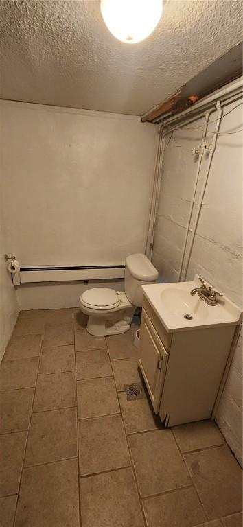 bathroom featuring toilet, tile patterned flooring, a textured ceiling, and vanity