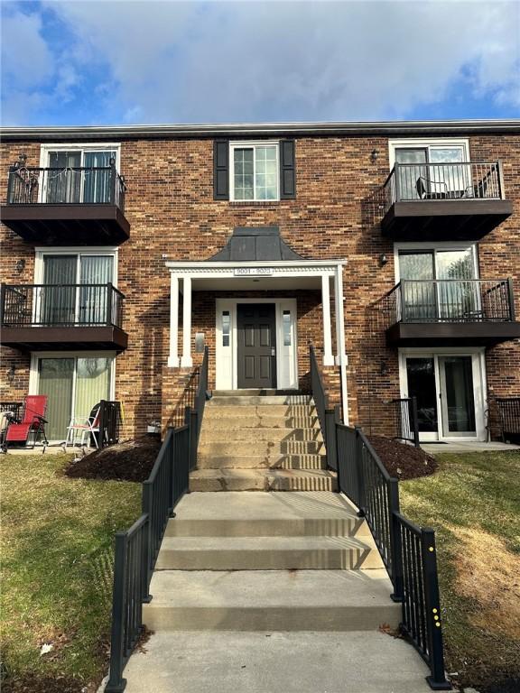 view of front of house featuring brick siding and a front lawn