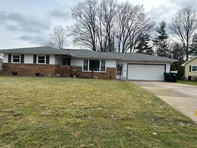 ranch-style home featuring driveway, a garage, crawl space, a front yard, and brick siding