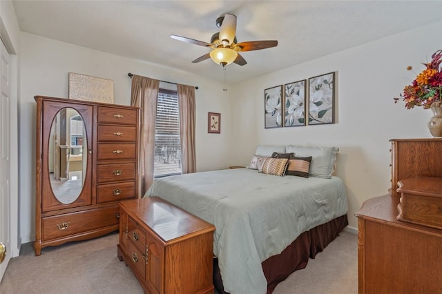 bedroom with a ceiling fan and light colored carpet