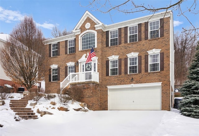 colonial-style house with an attached garage, stairs, and brick siding