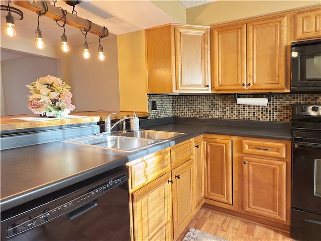 kitchen with black appliances, dark countertops, a sink, and decorative backsplash