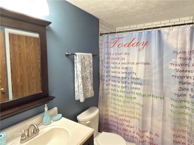 full bathroom featuring a textured ceiling, curtained shower, vanity, and toilet