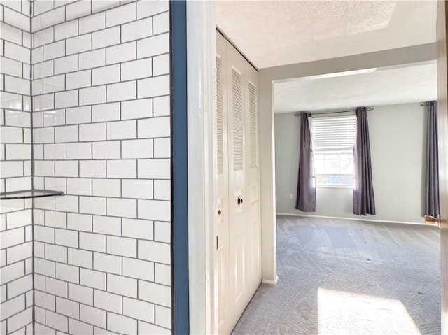 bathroom featuring a closet, a textured ceiling, and baseboards