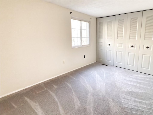 unfurnished bedroom with carpet floors, a closet, and baseboards