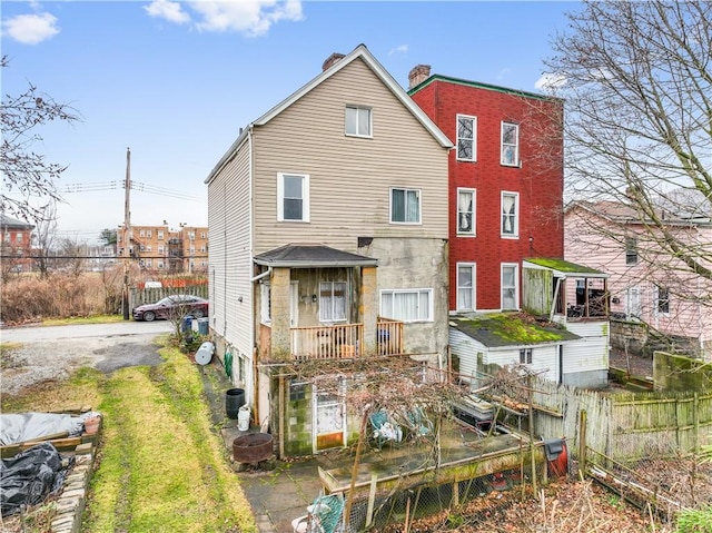 back of house featuring central AC and fence