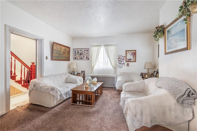 carpeted living room with a textured ceiling, stairway, and radiator