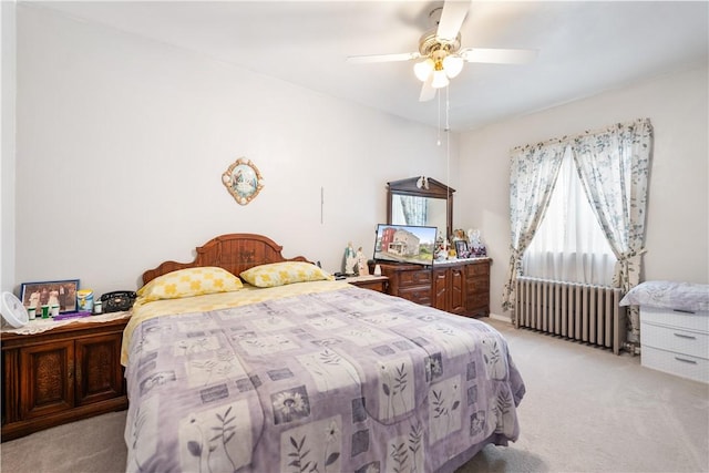 bedroom with light carpet, radiator heating unit, and a ceiling fan