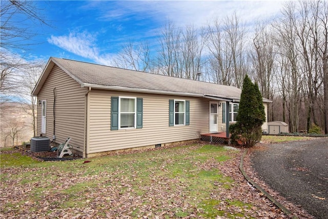 view of front of house featuring crawl space, a shed, cooling unit, and an outdoor structure