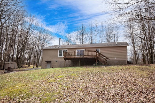 rear view of property featuring a storage shed, a deck, stairway, and an outdoor structure