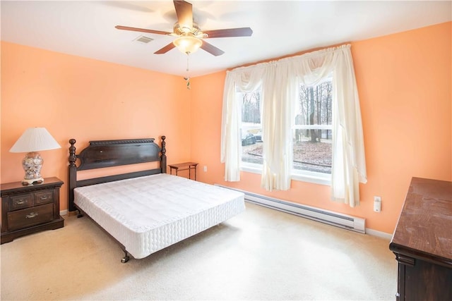 carpeted bedroom featuring baseboard heating, a ceiling fan, and baseboards