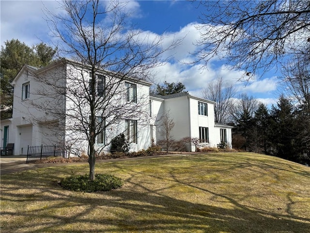 view of front of property with a garage, a front lawn, concrete driveway, and stucco siding