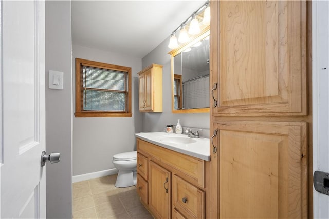 bathroom with baseboards, vanity, toilet, and tile patterned floors