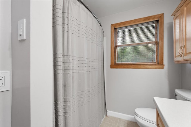 bathroom with tile patterned flooring, baseboards, vanity, and toilet