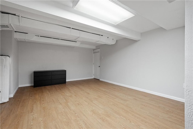 unfurnished room featuring light wood finished floors, visible vents, and baseboards