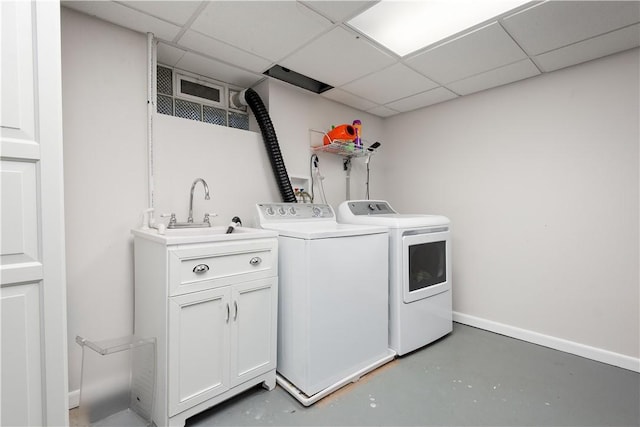 washroom featuring baseboards, separate washer and dryer, and a sink