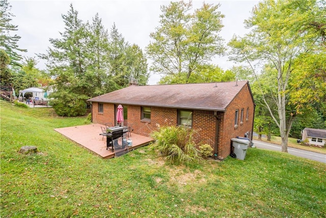 back of house with brick siding, a lawn, and a wooden deck