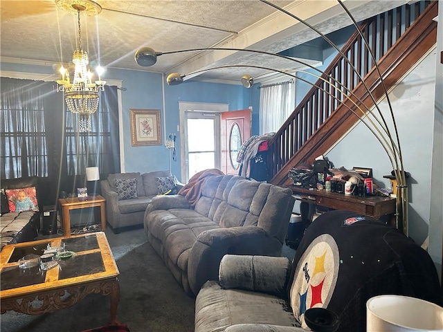 living room with stairs and an inviting chandelier