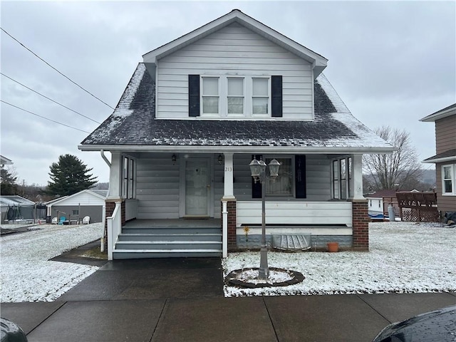 bungalow-style house featuring a porch and roof with shingles