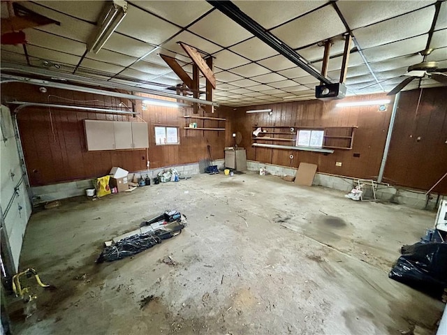 garage featuring a garage door opener and wooden walls