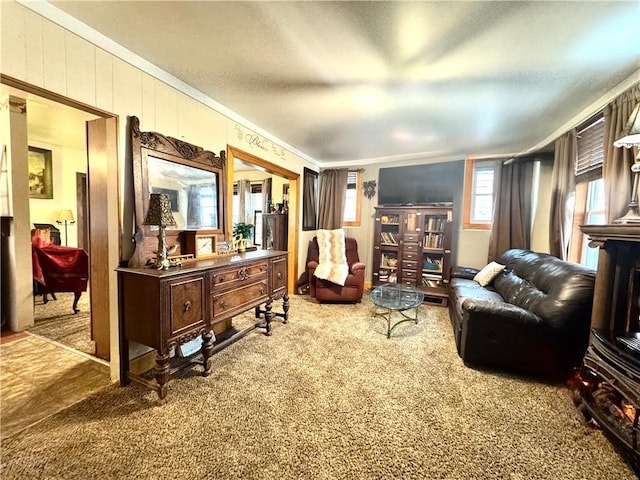 sitting room featuring wood walls, carpet flooring, and crown molding