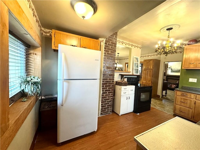 kitchen featuring a chandelier, dark wood-type flooring, black electric range, freestanding refrigerator, and dark countertops